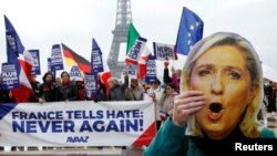 Fransada prezident seçkisindən sonra keçirilən nümayişdən foto, bir nəfər Marine Le Pen-in maskasını tutub