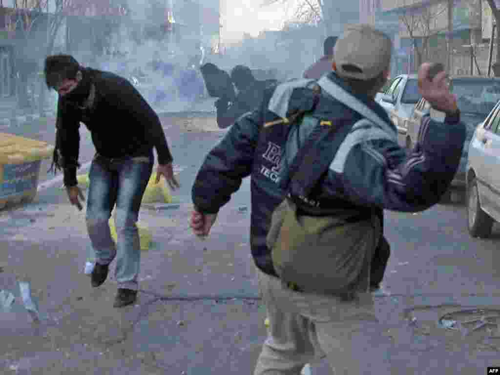 Protesters throw stones at riot police during an antigovernment demonstration in Tehran on February 14, held in support of the Arab uprisings in neighboring countries. (AFP)