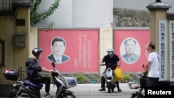 Портреты президента Китая Си Цзиньпина (слева) и покойного китайского лидера Мао Цзэдуна на одной из улиц Шанхая. Си готовится к третьему сроку в качестве лидера, чего не было со времен Мао Цзэдуна