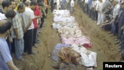 People gather during the mass burial of people whom activists say were killed by forces loyal to Syria's President Bashar al-Assad in Jdeidet Artouz, 01Aug2012