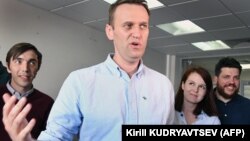 Aleksei Navalny (center) makes a statement for media in his office in Moscow in July 2017, as Kira Yarmysh stands behind him.