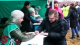 Ілюстрацыйнае фота. Прапагандыст Рыгор Азаронак ставіць подпіс у падтрымку вылучэньня Аляксандра Лукашэнкі кандыдадатам у прэзыдэнты. 7 лістапада 2024 году