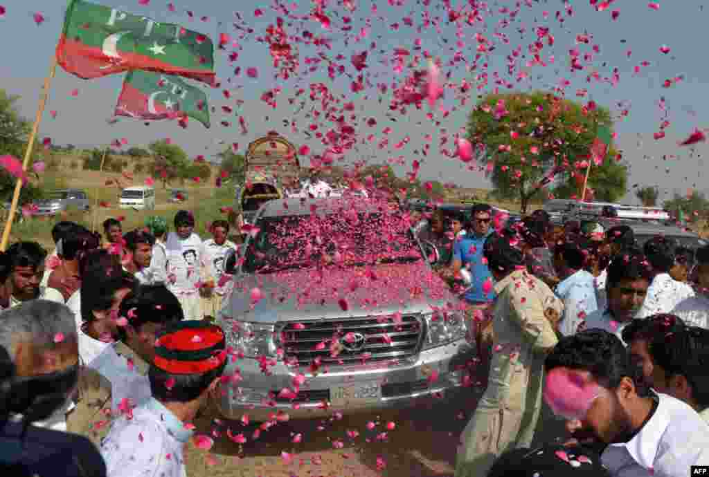 OCTOBER 6, 2012 -- People welcome the convoy of Pakistani politician Imran Khan, as it heads to the South Waziristan tribal region to protest U.S. drone missile strikes near the Afghan border. (AFP/A. Majeed)