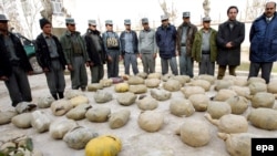 Afghan police inspect piles of heroin discovered during an operation in Herat in January 2010.