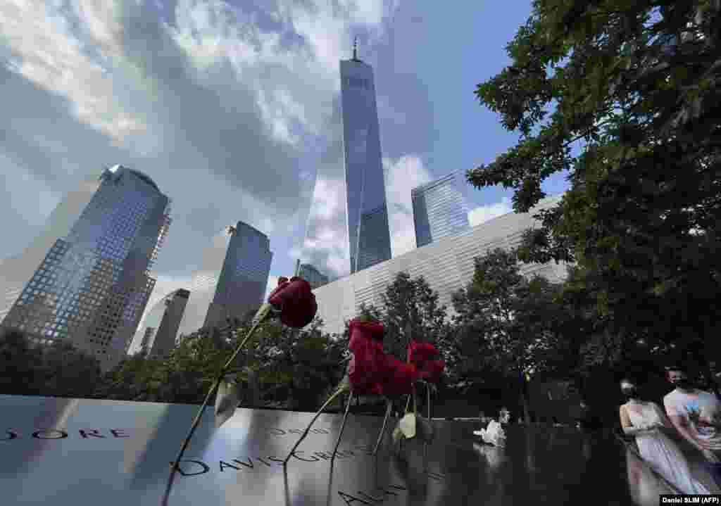 Qendra e rindërtuar Botërore e Tregtisë shihet në prapavijën e vendit përkujtimor të 11 Shtatorit, ku janë lënë trëndafila në nderim të viktimave. (Nju-Jork, 18 korrik 2021)