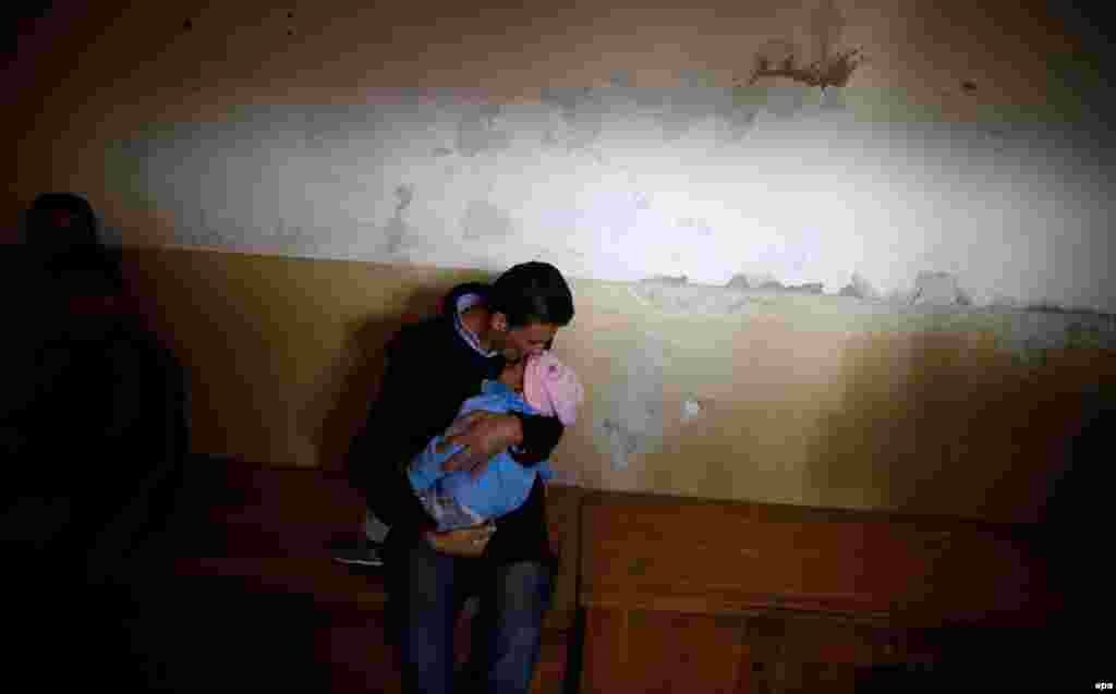 A man kisses his baby at a room in a temporary refugee camp in Vrazdebna, Bulgaria. (epa/Vassil Donev)