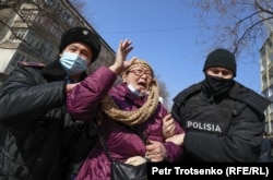Полиция үкіметке наразылық білдіріп, бейбіт митингіге шыққан адамды күштеп әкетіп барады. Алматы, 28 ақпан 2021 ж.