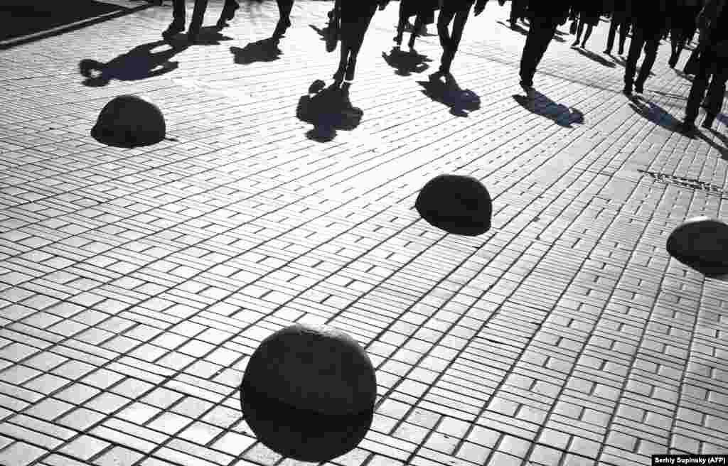 Pedestrians cast shadows during a sunny autumn day in the center of Kyiv. (AFP/Sergei Supinsky)