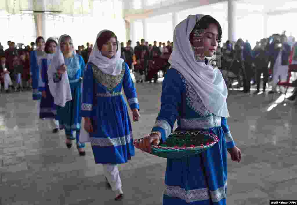 Before: Afghan women model traditional clothing at a fashion show in Kabul in December 2015.