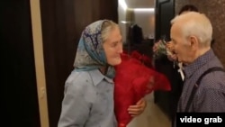 Babushka Lida meets her idol, singer Charles Aznavour, backstage in a Moscow concert hall.