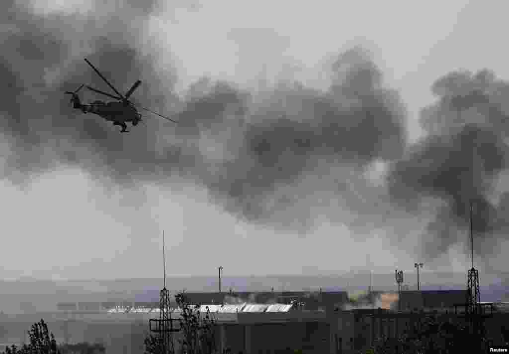 A Ukrainian Mi-24 helicopter gunship fires its cannons at rebels at the main terminal building of Donetsk&#39;s international airport on May 26.