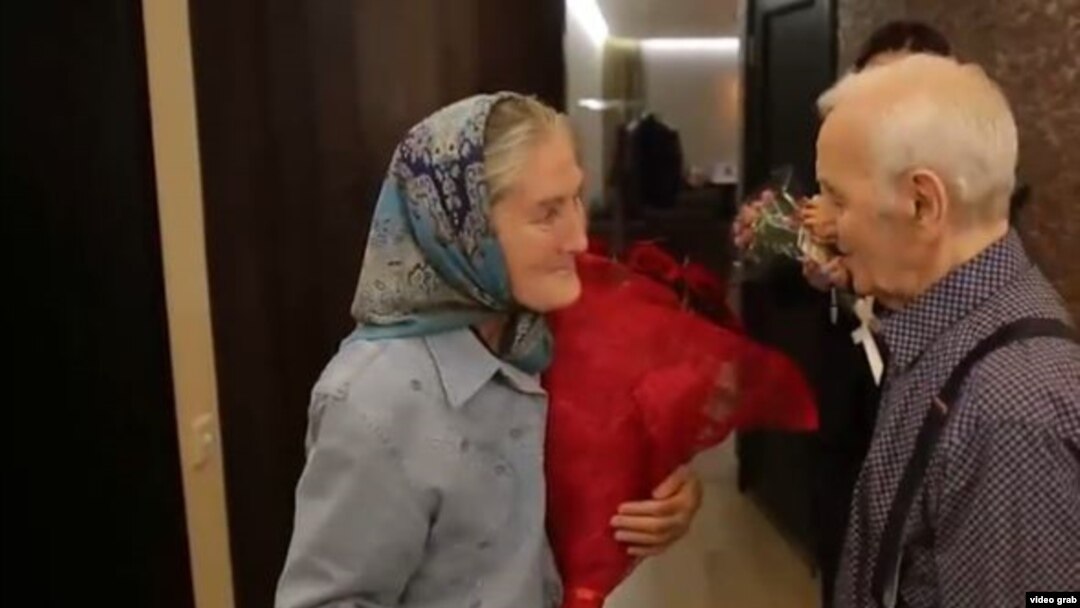 Babushka Lida meets her idol, singer Charles Aznavour, backstage in a Moscow concert hall.
