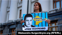 Катерина Єсипенко тримає плакат із обличчям полоненого чоловіка, журналіста Владислава Єсипенка, під Офісом президенти України. Липень 2021 року
