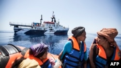 Мигранттарды куткаруу операциясы учурунда аялдар кайыкта отурушат. Жер ортолук деңизиндеги Сицилиянын жээги. 3-май, 2015-жыл