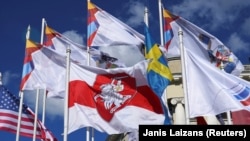 ბელარუსის ისტორიული თეთრ-წითელ-თეთრი დროშა ჰოკეის მსოფლიო ჩემპიონატში მონაწილე ქვეყნების დროშებს შორის. რიგა, 2021 წ. 24 მაისი.