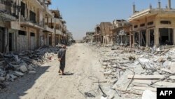 A Syrian man inspects the damage in the town of Khan Sheikhun in Idlib Province in August.