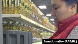 Гульмира Кусаинова, старший продавец супермаркета, снимает ценник о продаже льготного подсолнечного масла. Уральск, 6 ноября 2015 год.