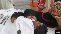 Pakistan -- Family members mourn next to the body of a man killed in a target killing, at a local hospital, in Karachi, 22Jul2011