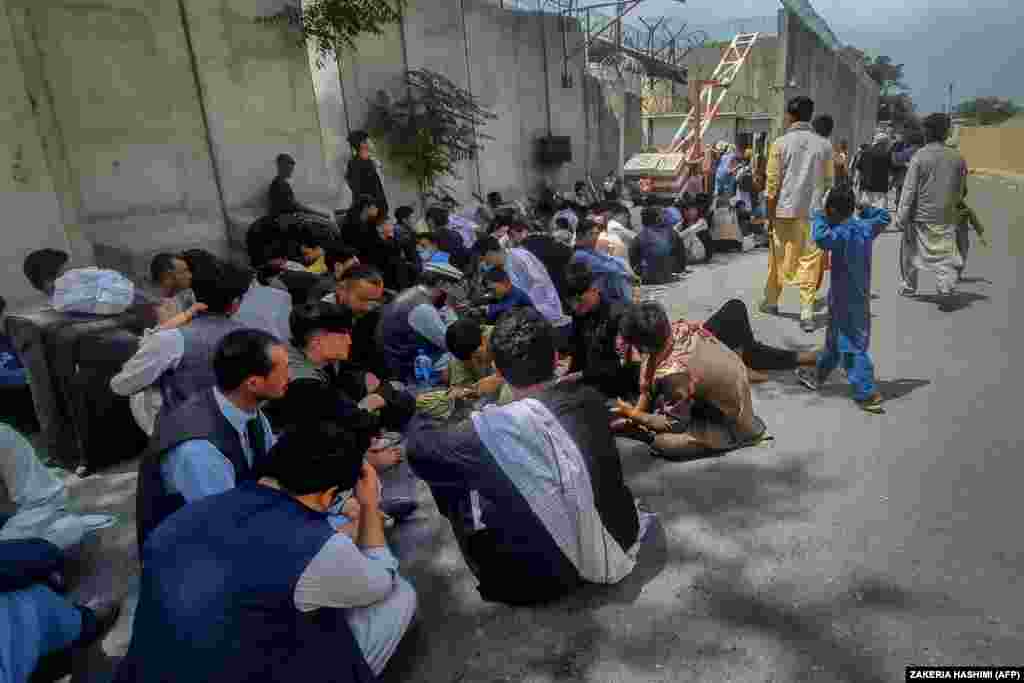 Afghans sitting outside the French Embassy in Kabul on August 17 waiting to leave Afghanistan.