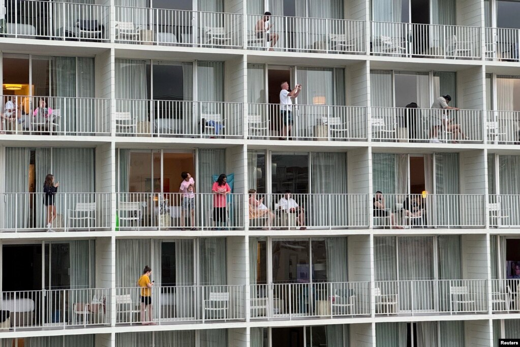 Mysafirë të një hoteli në Honolulu vëzhgojnë nga ballkoni plazhin përreth, në Havai, SHBA, më 29 korrik 2025.