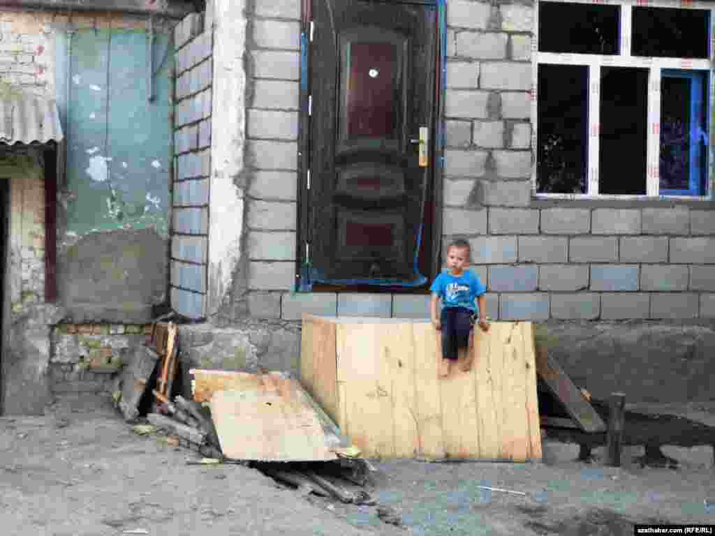 Aşgabadyň 6-njy mikroraýonynda ýykylýan pristroýkalara haýran galyp seredip oturan bir çaga