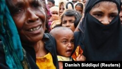 Bangladesh - A Rohingya refugee baby cries as his mother jostles for aid in Cox's Bazar, Bangladesh September 20, 2017. 