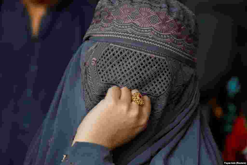 A burqa-clad Afghan woman living in Pakistan waits to get registered during a registration drive at United Nations High Commissioner for Refugees office in Peshawar, Pakistan, on September 30.