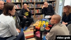 Belarusian opposition leader Svyatlana Tsikhanouskaya (front left) meets freed prisoners, including former RFE/RL journalist Ihar Karnei (third from left), in Lithuania.