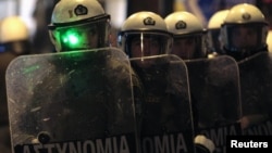 A Greek policeman has his face illuminated by a green laser beam during an anti-austerity protest outside the Greek parliament in Athens' Syntagma square on February 19.