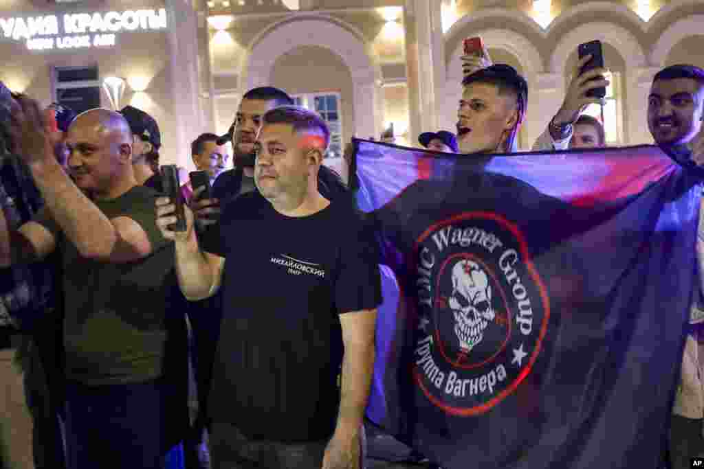 People cheer and wave a Wagner flag near the military headquarters in Rostov-on-Don. The Kremlin said Belarusian strongman Alyaksandr Lukashenka helped mediate the deal. Kremlin spokesman Dmitry Peskov said Putin and Lukashenka had guaranteed Prigozhin&#39;s safety. &nbsp;