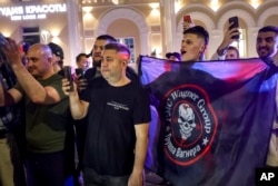 Мъже в Ростов на Дон снимат изтеглянето на "Вагнер" и носят знамена с логото на формированието