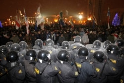 Riot police block demonstrators trying to storm the government building in Minsk on December 19, 2010.