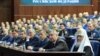 Дмитрий Рогозин был связан с подготовкой военной техники РФ. На фото он сидит возле патриарха Кирилла на коллегии Министерства обороны России в 2015 году