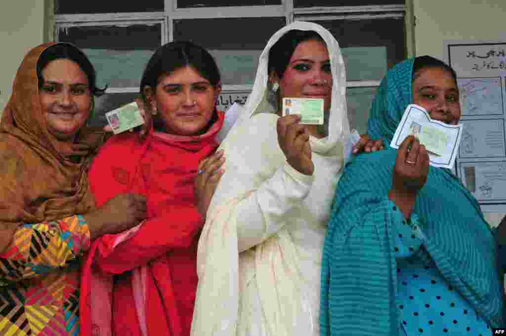 Female Pakistani voters pose with their national identity cards as they queue to cast their ballots at a polling station during the general elections in Rawalpindi. Women were warned by the Pakistani Taliban to stay home. (AFP/Farooq Naeem)