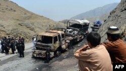 Pakistani security personnel gather beside torched NATO supply trucks after an attack by armed militants in the northwestern Khyber district in June. 