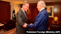 Pakistani Foreign Minister Shah Mahmud Qureshi (left) receives Zalmay Khalilzad in Islamabad on January 18.