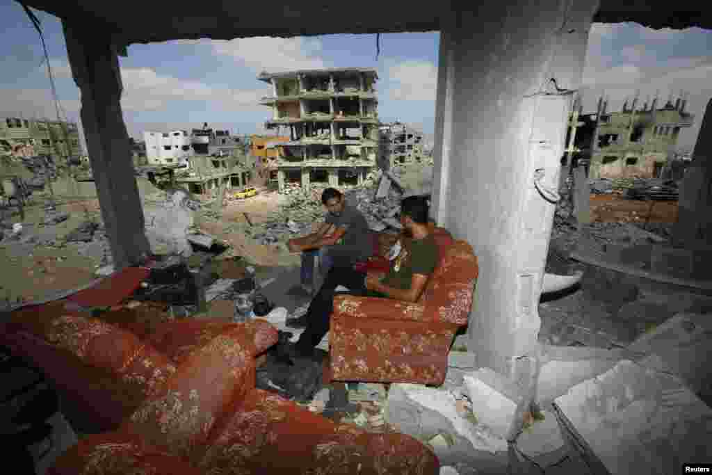 Palestinians sit on a couch as they return to the remains of their house, which witnesses said was destroyed in an Israeli offensive, after a cease-fire was declared with Israel, in the east of Gaza City on August 27. (Reuters/Suhaib Salem)