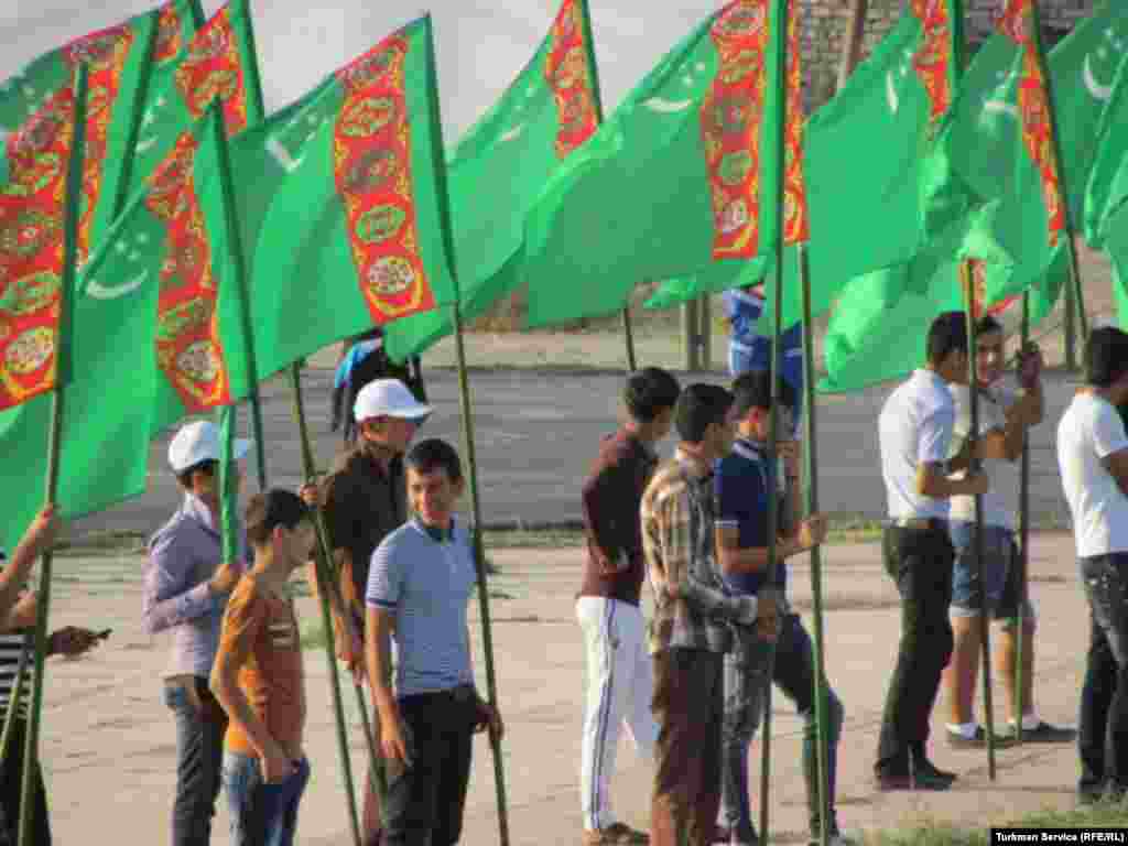 Young men with Turkmen flags rehearse for the country's Independence Day celebrations in Turkmenabat. 
