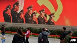 Tourists walk through Tiananmen Square on the eve of the Chinese Communist Party Congress to elect a new leader in Beijing.