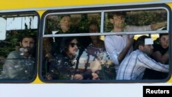 Gay-rights activists look out from a bus as they are evacuated by police during clashes in Tbilisi on May 17.