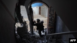 Ushtarët izraelitë duke e bastisur një ndërtesë në veri të Rripit të Gazës më 12 dhjetor 2023.