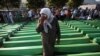 Bosnia-Herzegovina -- Bosnian Muslim woman cries near coffins prepared for a mass burial at the Memorial Center in Potocari, near Srebenica, 11Jul2011