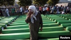 Bosnia-Herzegovina -- Bosnian Muslim woman cries near coffins prepared for a mass burial at the Memorial Center in Potocari, near Srebenica, 11Jul2011