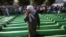 Bosnia-Herzegovina -- Bosnian Muslim woman cries near coffins prepared for a mass burial at the Memorial Center in Potocari, near Srebenica, 11Jul2011