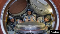 Астронавт НАСА Карен Найберг (слева), российский космонавт Федор Юрчихин и астронавт Европейского космического агентства Лука Пармитано на тренировочных занятиях. Звездный городок, 26 апреля 2013 года.
