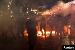 Një person duke hedhur fishekzjarrë gjatë protestës në Tiranë.
