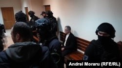 Vladimir Plahotniuc a stat singur pe banca acuzaților, în spatele unui cordon de polițiști.