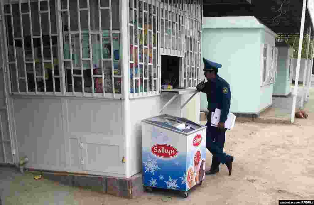 Dükandar bilen gürleşip duran polisiýa işgäri