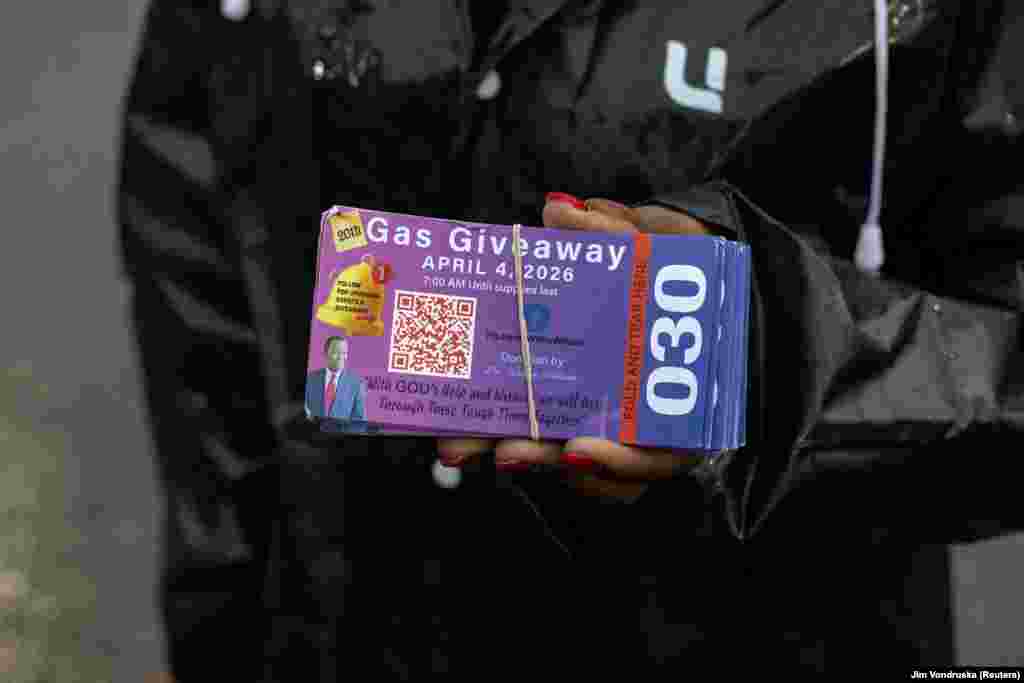 A volunteer in the American state of Chicago holds a coupon at a gas station on April 4 during an event in which a local businessman has pledged to gift $200,000 worth of petrol.