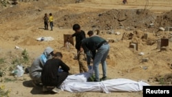 Palestinezët gjejnë trupa të varrosur në një varr masiv gjatë konfliktit të tanishëm mes Izraelit dhe Hamasit, në veri të Gazës, 15 prill 2024.